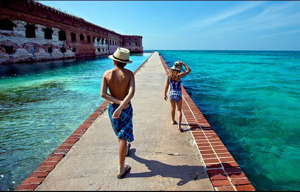 Two children walking a brick path in the water