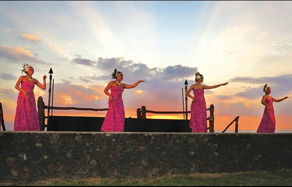 Four native hawaiian women doing a luau dance performance on stage
